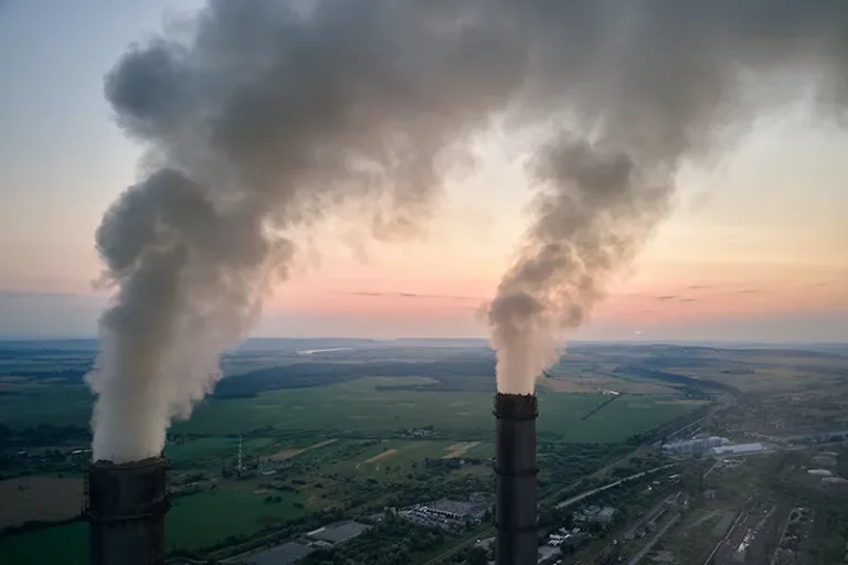 Rookpluimen en rook die uit een fabriek komt